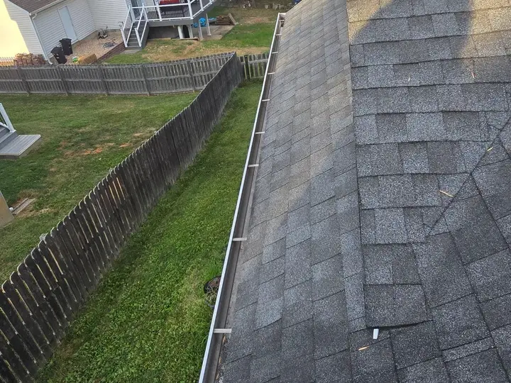 Shingle roof edge with a gutter running alongside the eave