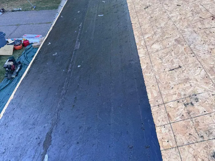Dark membrane along the roof edge beside exposed wood sheathing