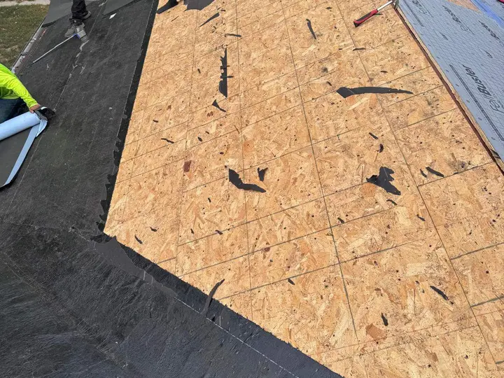 Exposed wood roof sheathing between membrane and underlayment sections