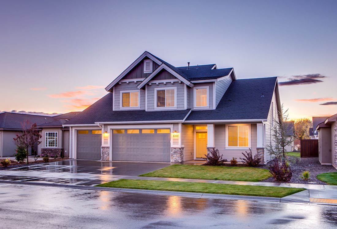 Suburban home with a dark shingle roof at dusk