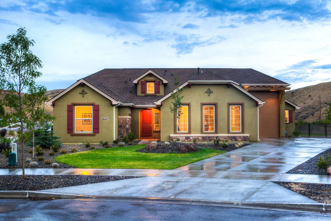 Shingle-roofed residential home with exterior lighting