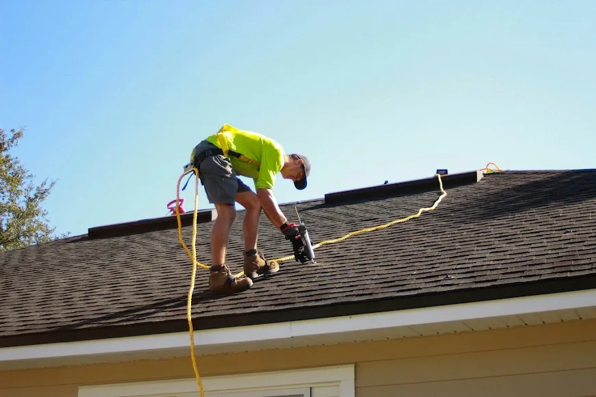 Roofer installing shingles